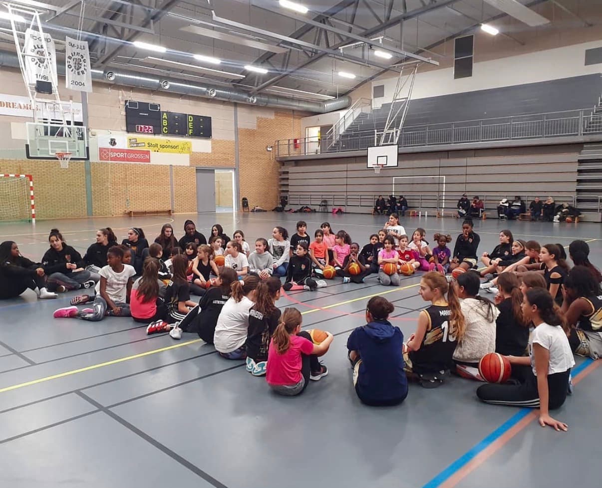 Spelare och tränare samlade i en ring i hallen
